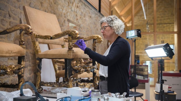 A conservator works on the Dolphin armchairs from Ham House in Surrey in The Royal Oak Foundation Conservation Studio, Knole, Kent